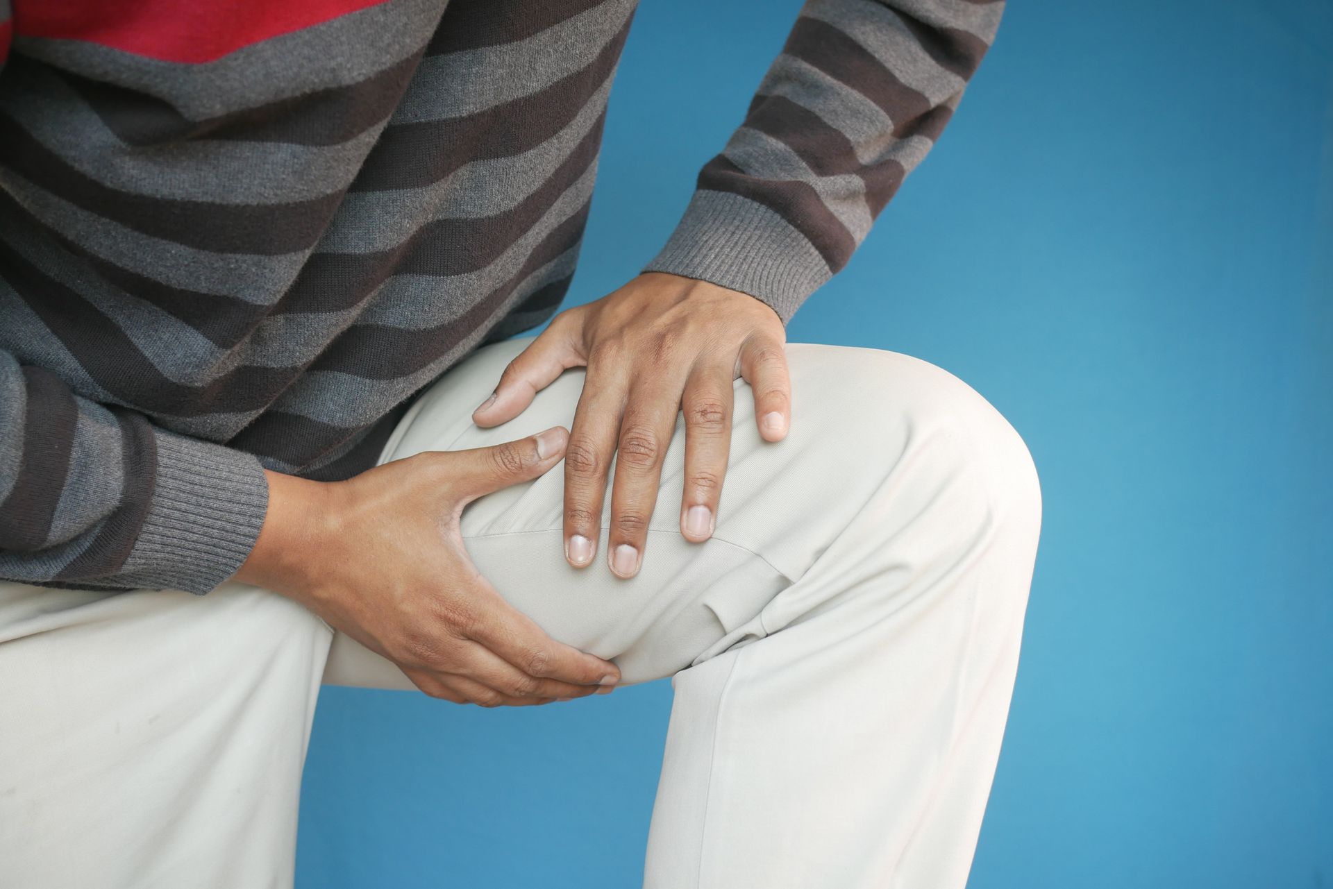 Person holding thigh due to burning nerve pain