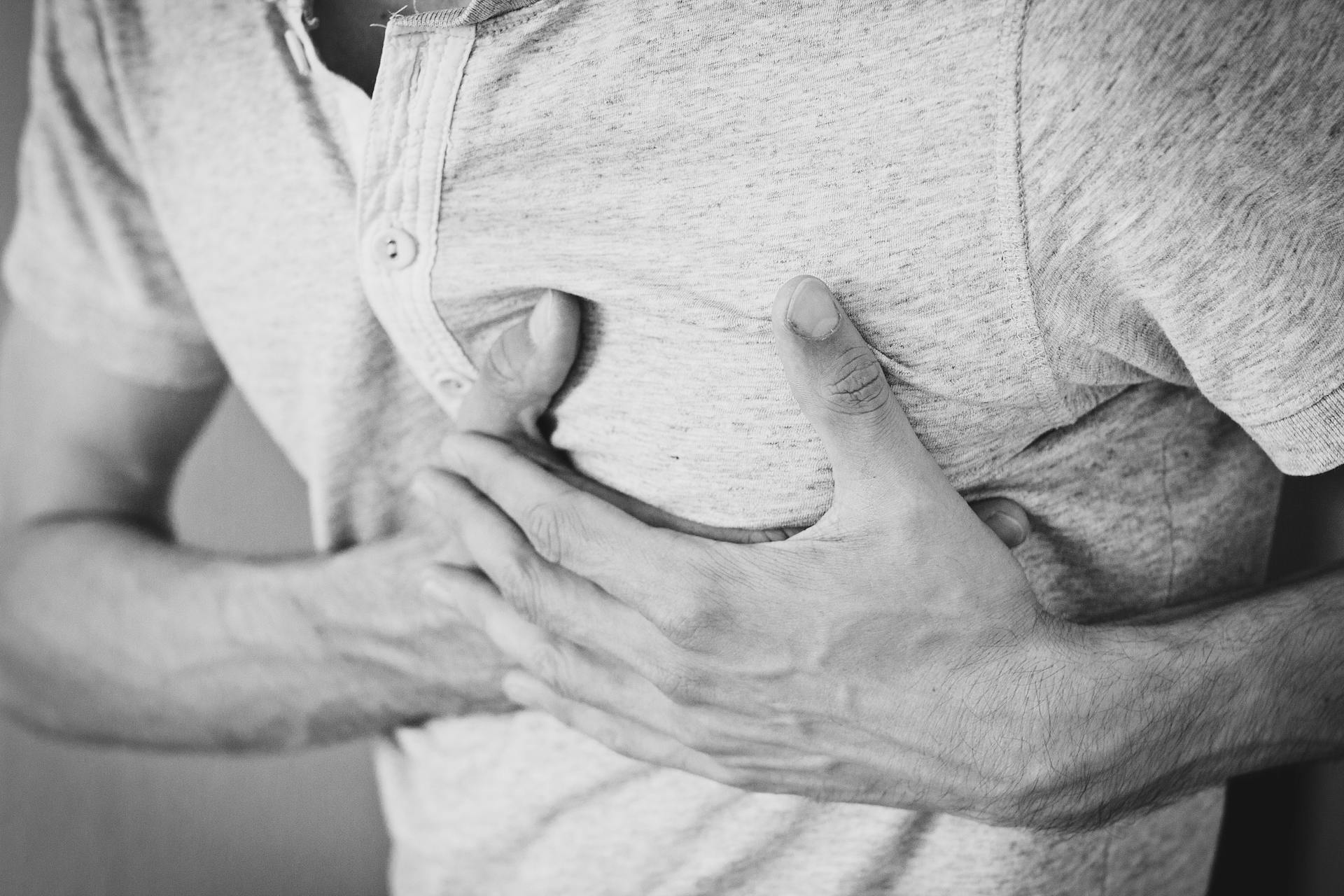 Man holding left chest due to chest wall pain