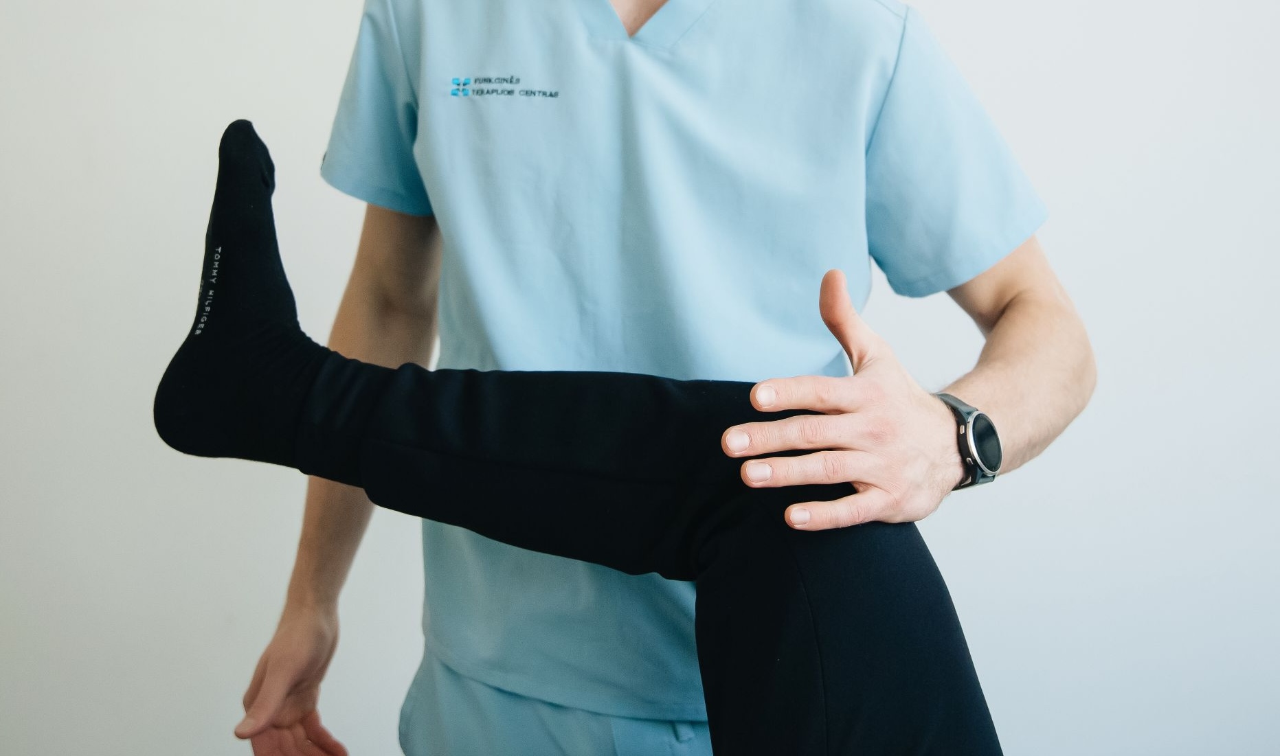 Physiotherapist assessing leg movement as part of gait and walking pain evaluation