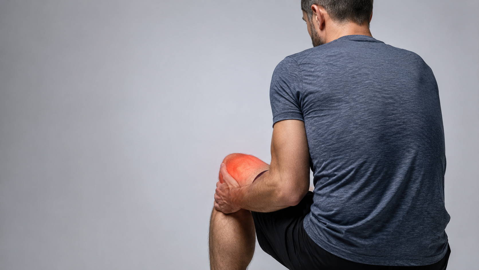 Seated man holding his knee with a red highlight indicating pain.
