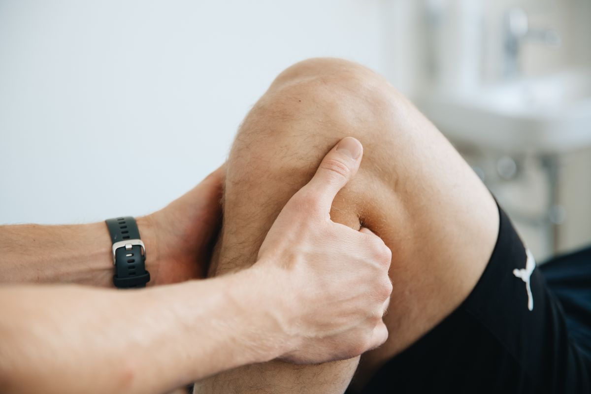 Close-up of hands assessing a bent knee.