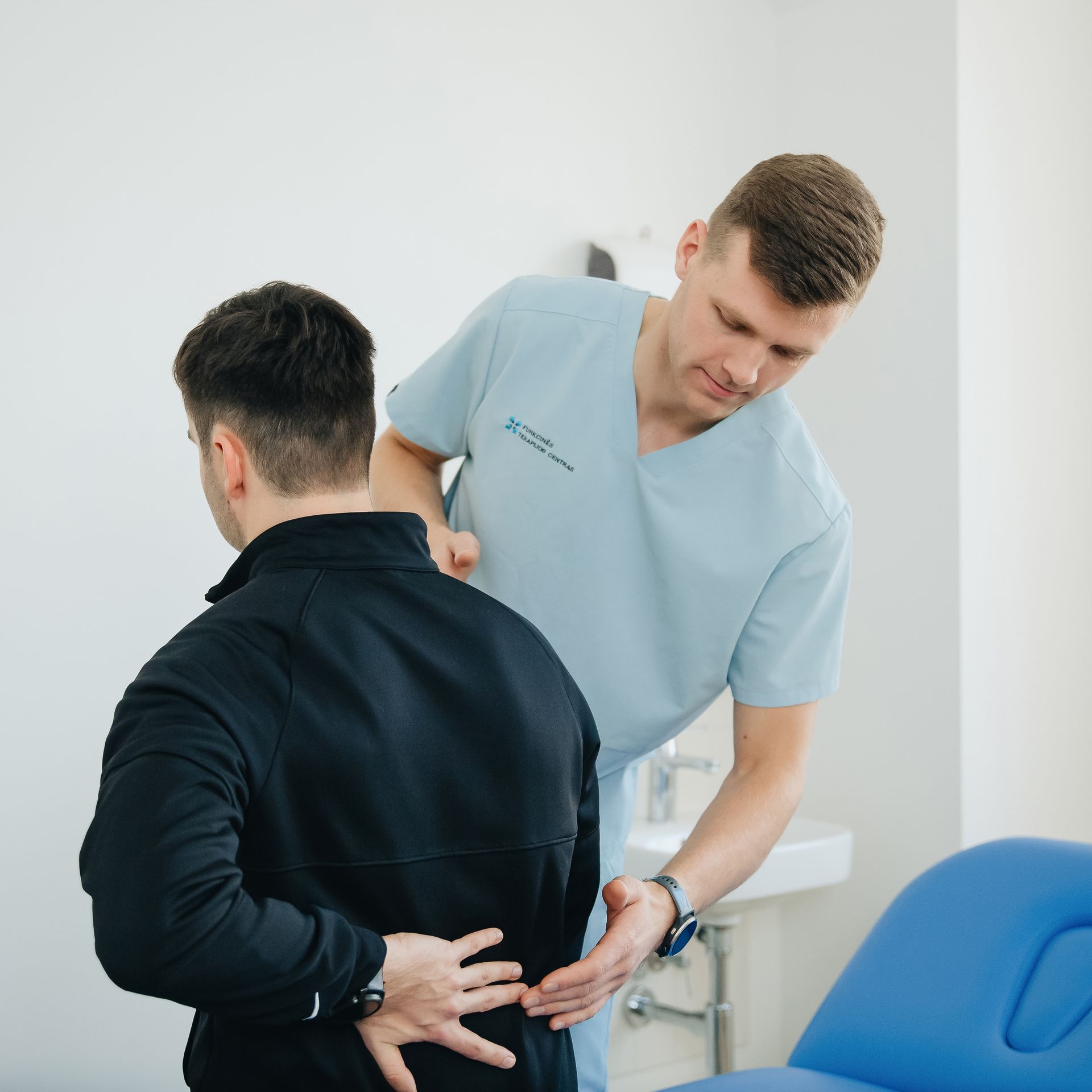 Doctor examining patient for low back pain diagnosis